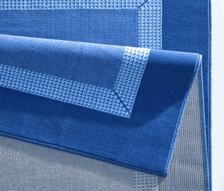 Basic tæppe i farven Blå lavet af 100% Polypropylen med en bagside af Jute